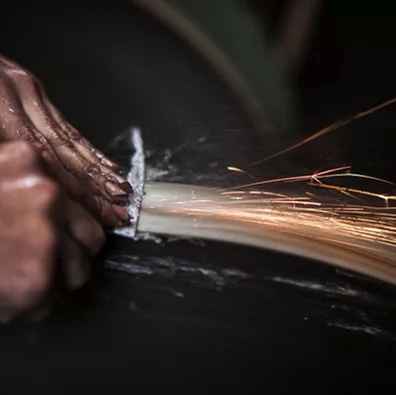 Professional knife sharpening on a grinding wheel